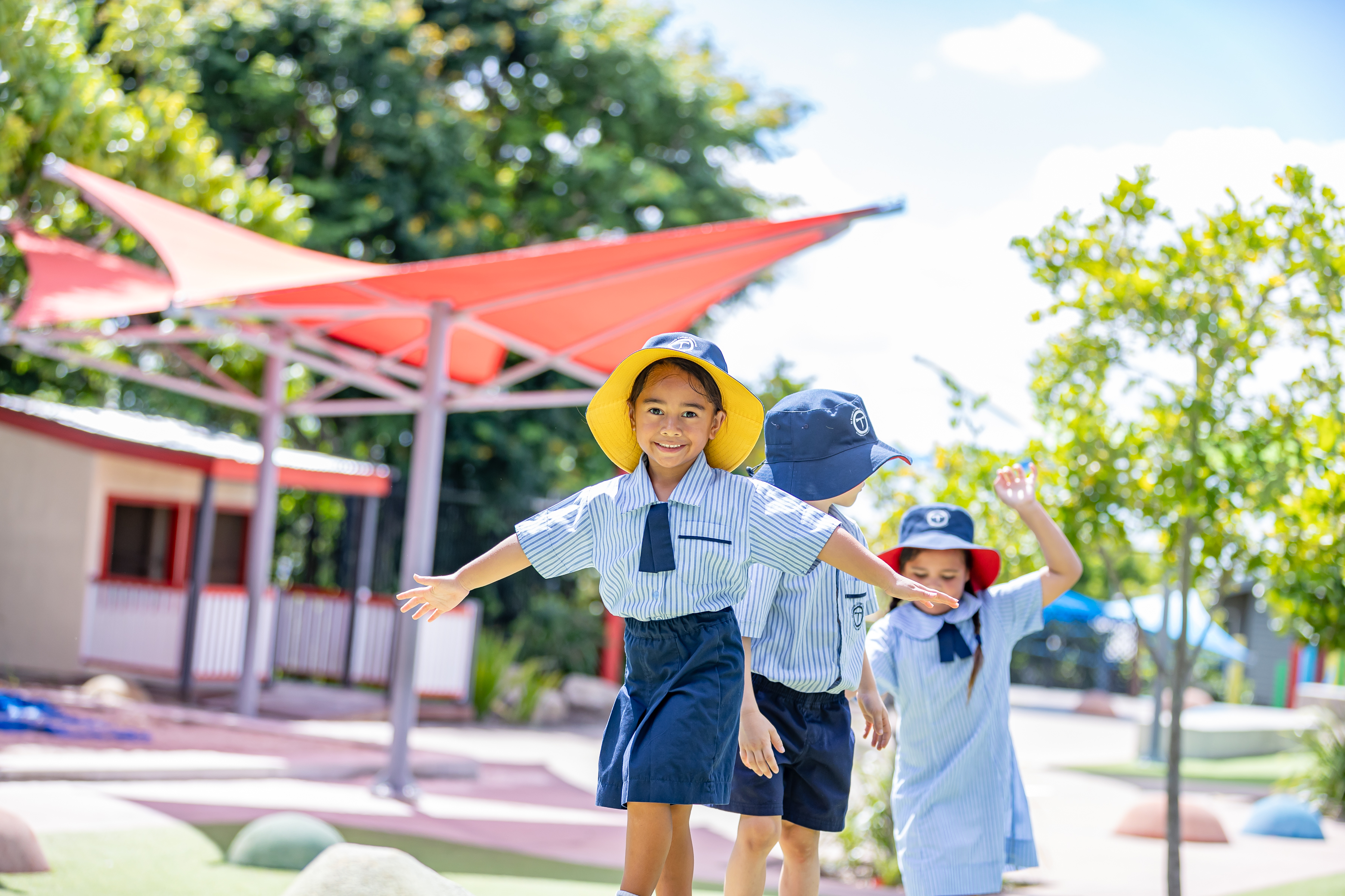 Early years students playing outdoors in a shaded playground, supporting active play, exploration and social development