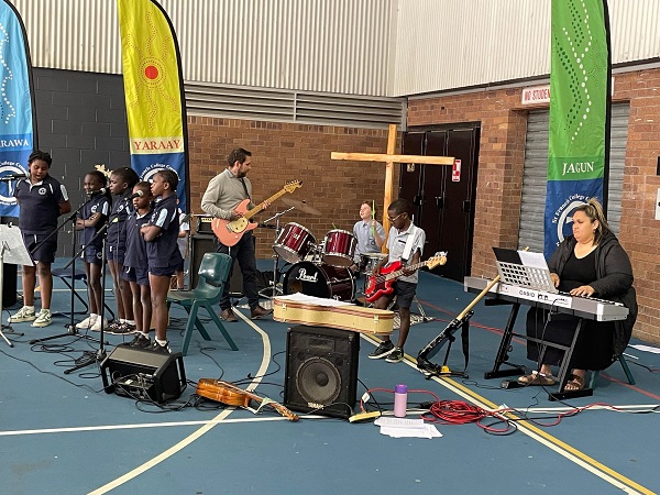 Students and staff performing music during a school event highlighting creativity and participation