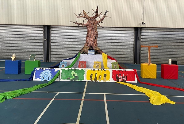 Liturgical display with tree, cross and coloured cloths representing stages of faith and action